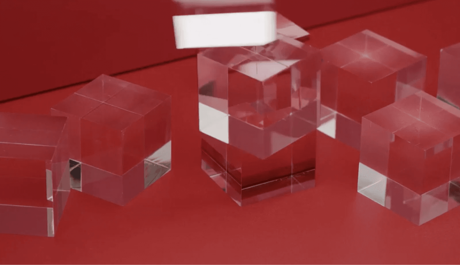adobe creative types 3 Translucent acrylic cubes are arranged on a vibrant red background, with one cube being dropped onto others.