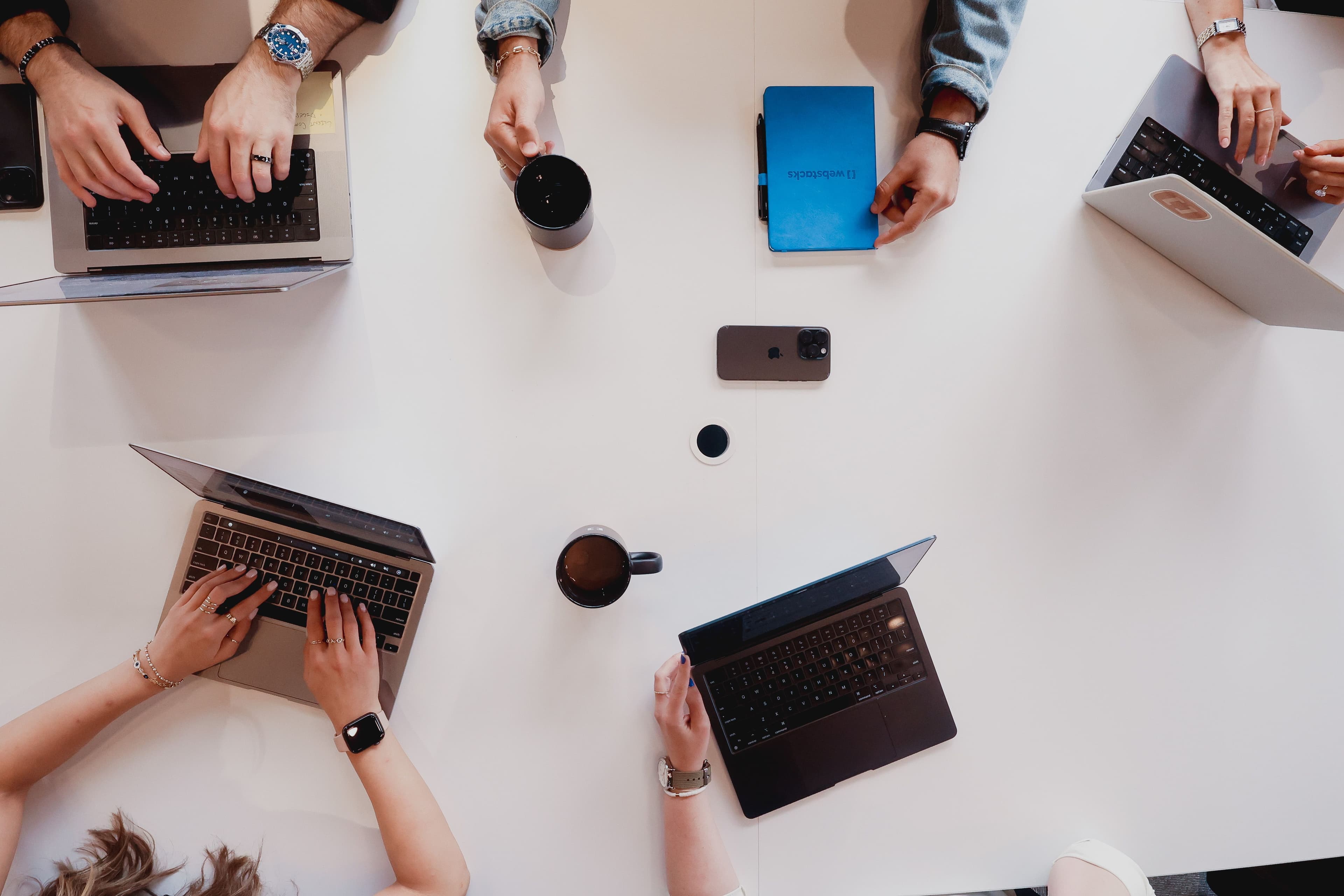Hands typing on keyboard during a work meeting