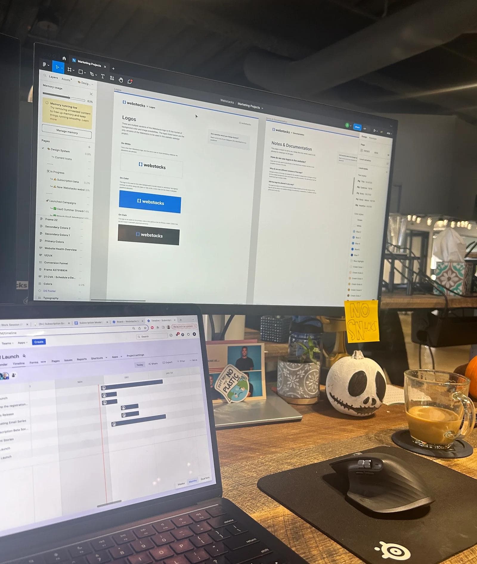 Eric BTB 4 A workspace with two monitors displaying project management tools, a coffee cup, and a decorative skull on the desk.