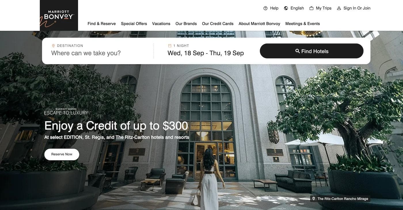 marriot website Marriott Bonvoy homepage featuring luxury hotel offers and a woman walking towards an elegant entrance.