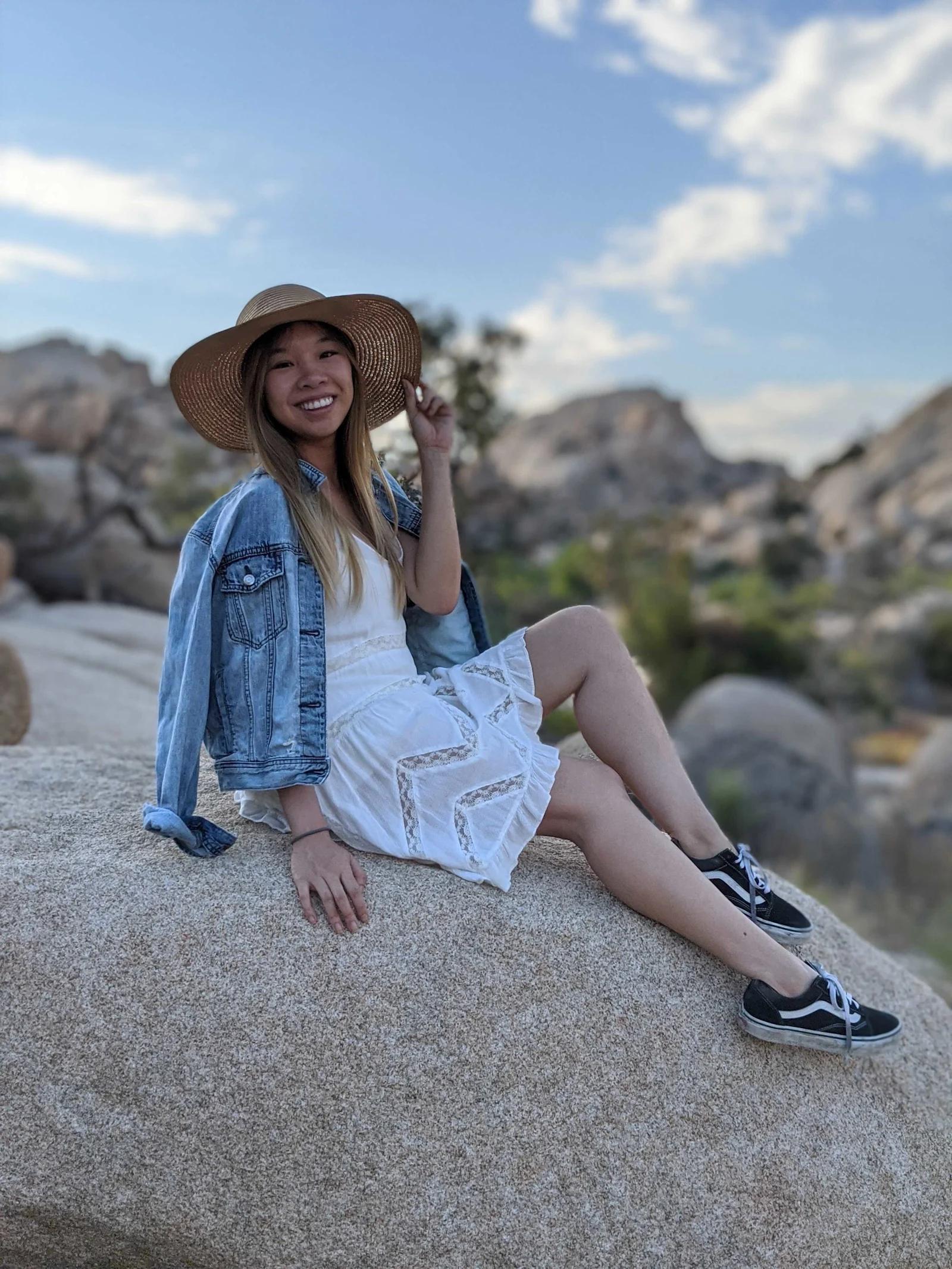 Tracy Yu sitting on a rock.