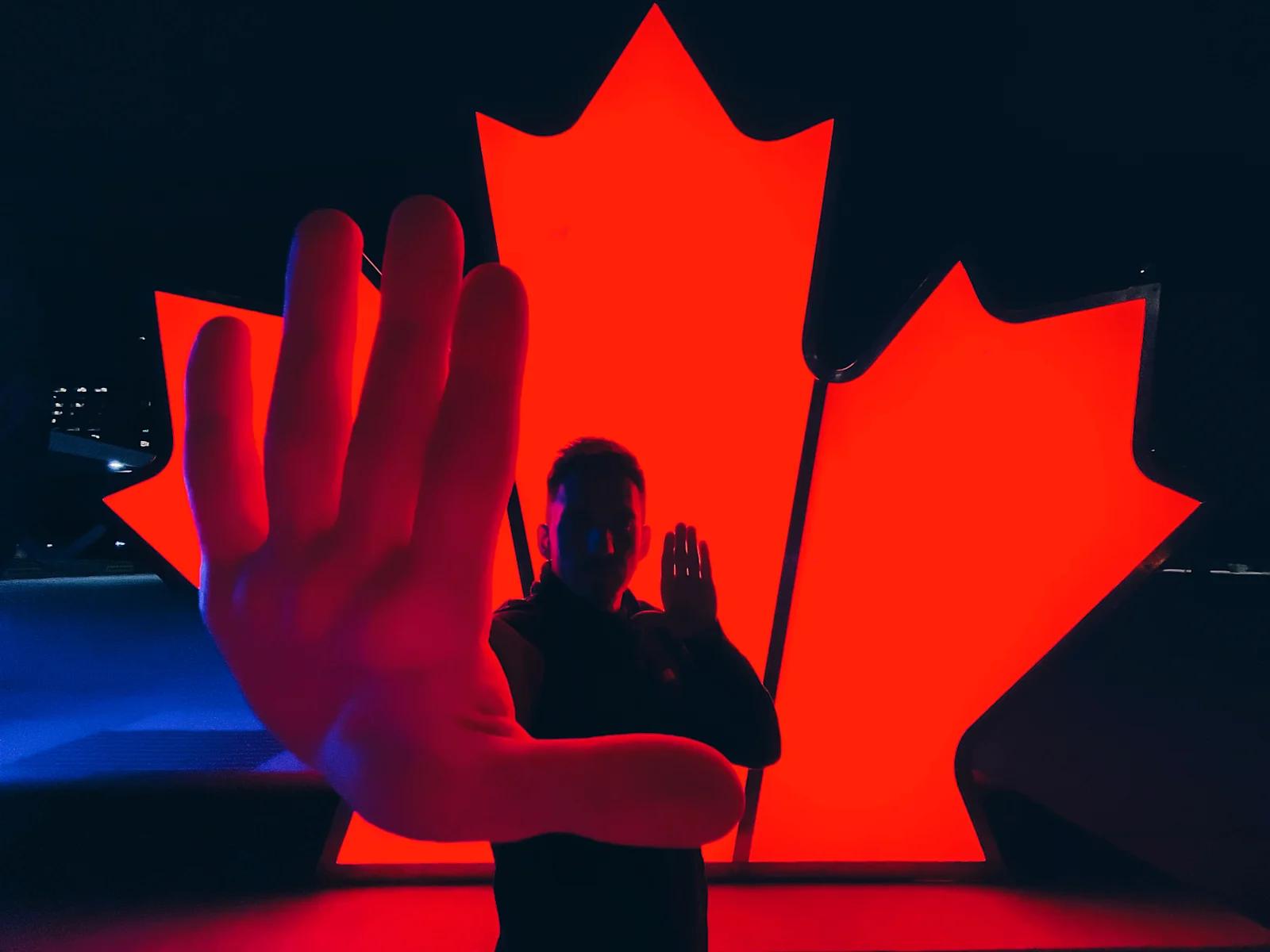 Seric in front of a red glowing maple leaf in Toronto, Canada.
