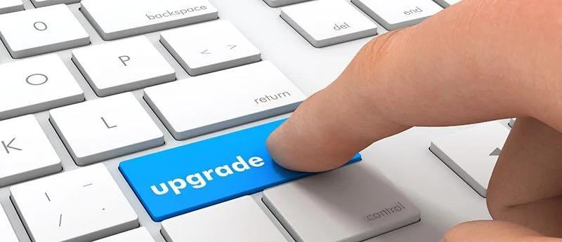 An image of a finger hitting a keyboard key labeled upgrade.