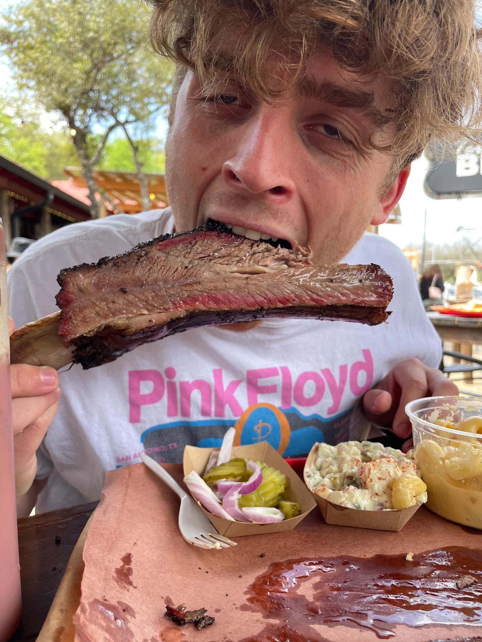 A picture of Sam eating a barbeque short rib.